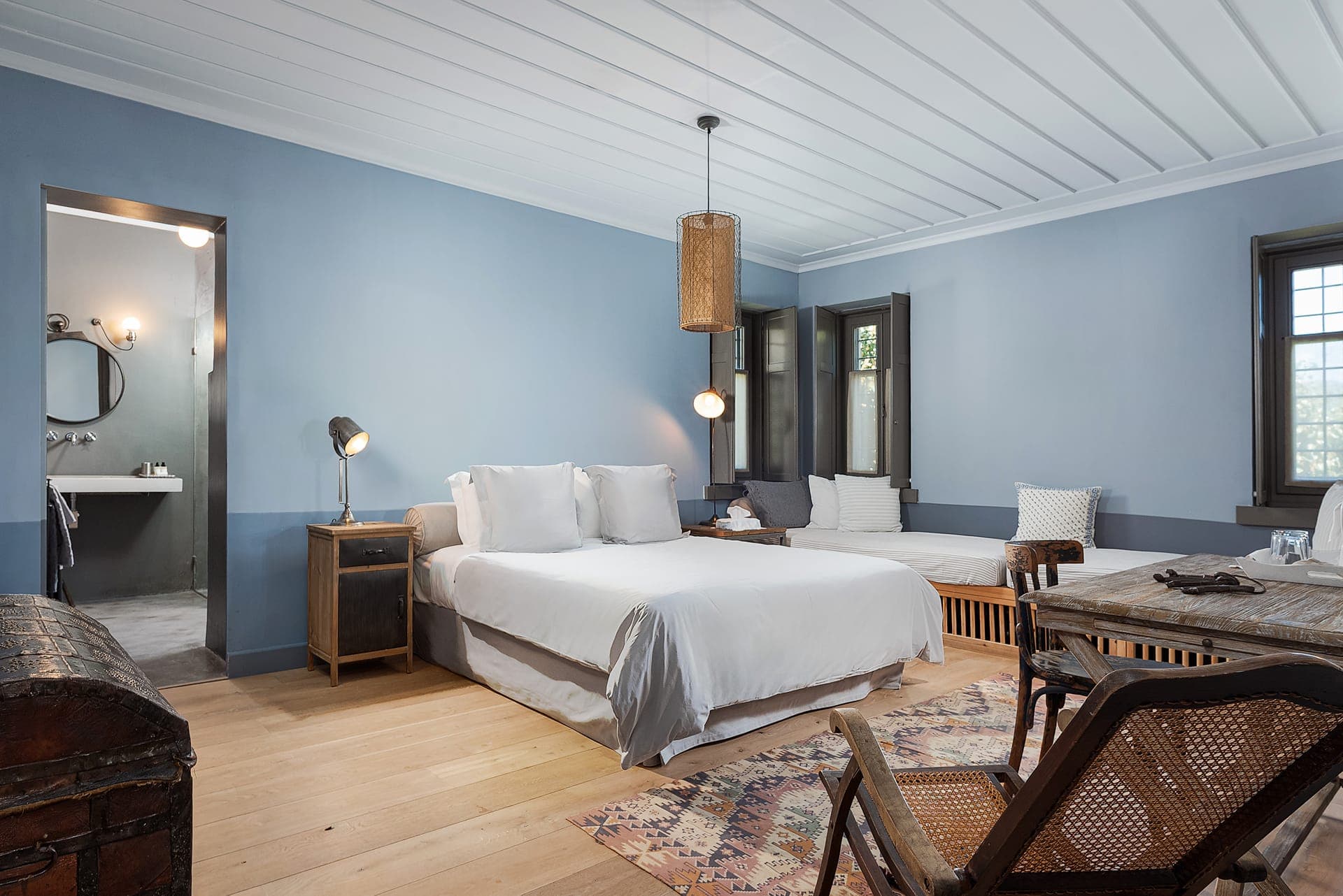 Blue Suite bedroom with seating area and mountain views.